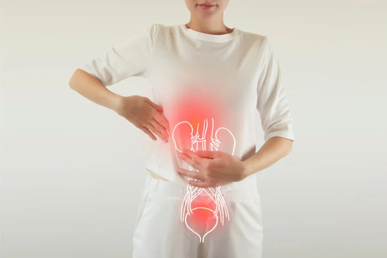 Mulher com a mão na barriga e uma imagem do aparelho digestivo ilustrando uma infecção urinária